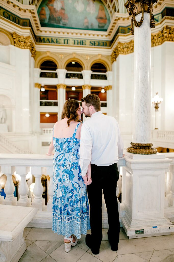 Man and his Washington D.C bride to be hold hands while looking at each other touching nose to nose at proposal in Washington D.C