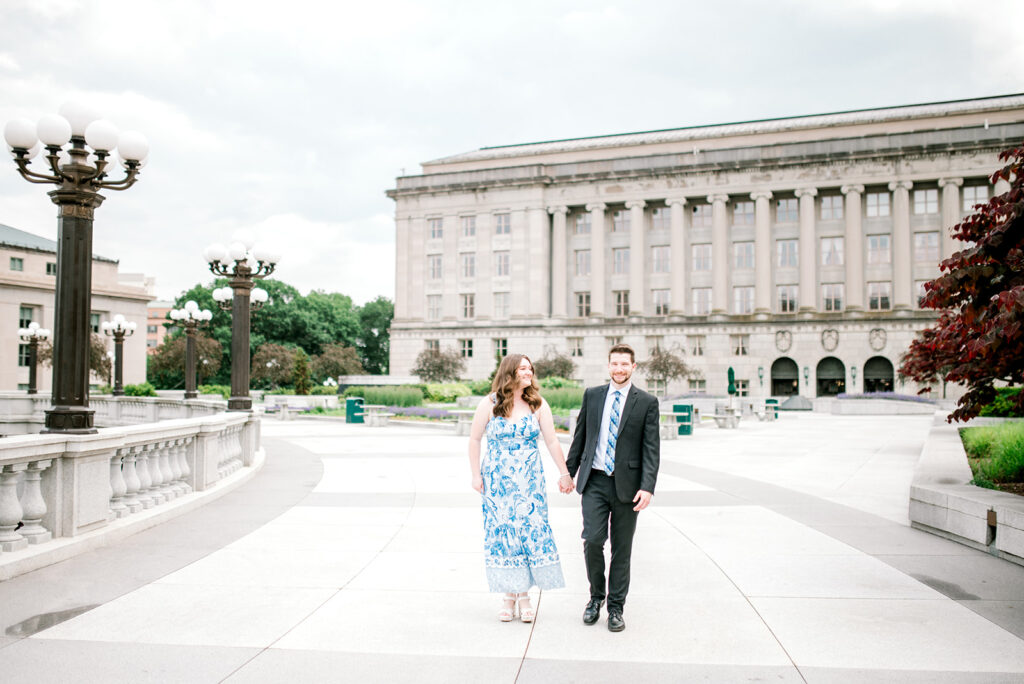 DC bride to be and groom to be look at each other in front of historical building with columns at beautiful proposal in Washington DC