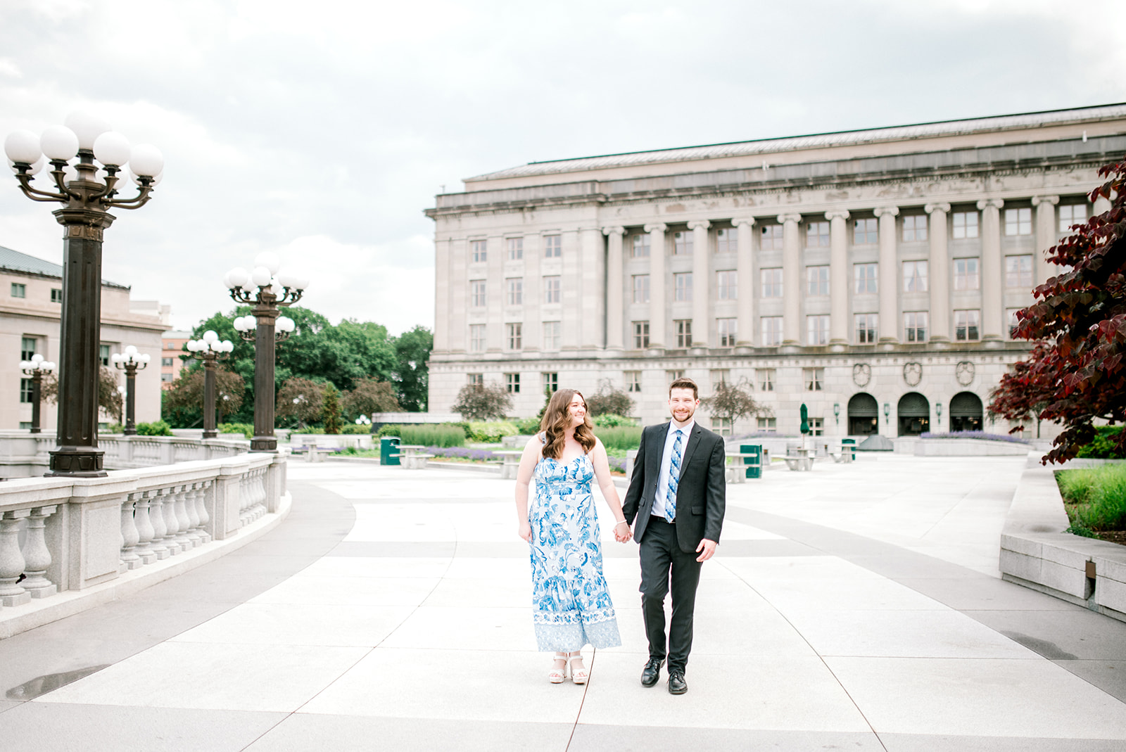 DC bride to be and groom to be look at each other in front of historical building with columns at beautiful proposal in Washington DC
